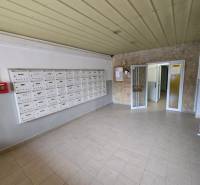 Hallway with mailboxes and tiled floor in an apartment building.