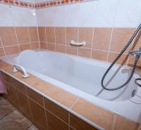 Bathroom in a 2-room apartment with a bathtub, tiled in light colors.