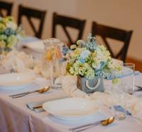 A table in a dining area with decorated plates and floral arrangements.