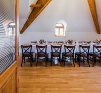 A table in a dining area with place settings and decorations, accessible through glass doors.