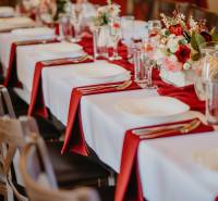 A table with red napkins, set for guests in a dining area.