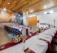 Interior of a gastro space with long tables, flowers, and a large wall mural.
