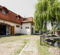 The exterior of the gastro spaces in Prešov with a bridge and a green garden.