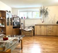Living room in a family house: wooden furniture, sofa, flowers, audio equipment, glass table.
