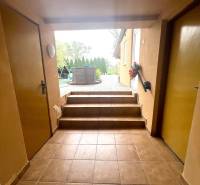 A hallway with stairs and tiles leads to the terrace in a family house.