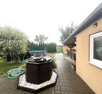 The courtyard of a family house in Veľké Chlievany with a swimming pool and a paved terrace.
