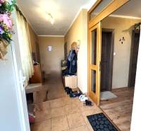 Entrance hallway in a family house with tiles and wooden doors.