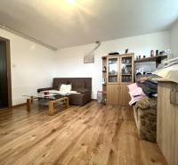 Living room in a family house with wooden flooring, a sofa, and a cabinet.