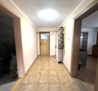 A hallway in a family house with two doors and tiled flooring.