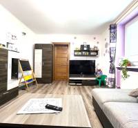 Living room in a family house with wooden furniture and decorations on the shelves.