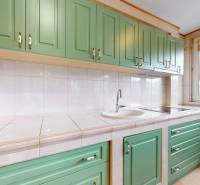 A kitchen with mint green cabinets and white tiles in commercial premises.