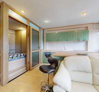 Commercial space with a kitchenette, bar stools, and a sofa in light shades.