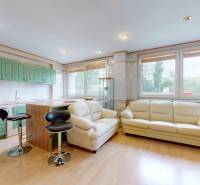 A kitchen with mint green cabinets, white leather couches, and bar stools in commercial premises.