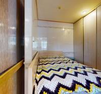 Bedroom with a bed, built-in wardrobe, and colorful blanket in commercial premises.