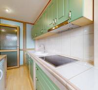 A kitchen with a wooden countertop and green cabinets in commercial premises.