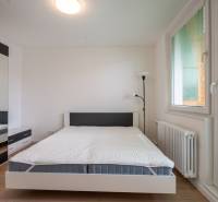 Bright bedroom in a 3-room apartment with a bed, wardrobe, and a balcony window.