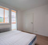 Bedroom in a 3-room apartment with a bed, windows, and a radiator, equipped with blinds.