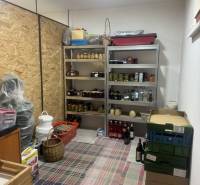 A pantry in a one-room apartment with shelves full of preserves and boxes.