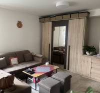 A comfortable living room in a studio apartment with a sofa, cabinet, and coffee table.