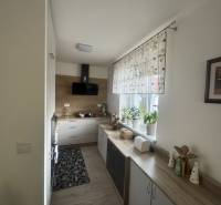 A cozy kitchen with a window and white cabinets in a studio apartment.