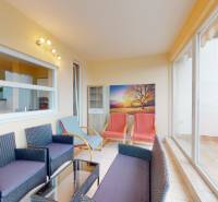 A glazed terrace in a 3-room apartment with seating and decorations.