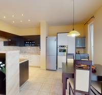 A kitchen with a dining table in a 3-room apartment with built-in appliances and modern-style cabinets.