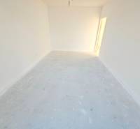 Empty room in a family house with white walls and simple flooring.