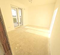 A spacious bright room in a family house with large French windows leading to the terrace.