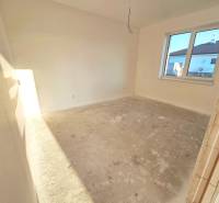 An unplastered room in a family house with light streaming through the window.