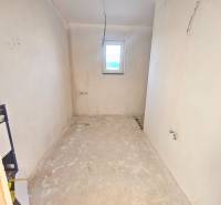 Room in a family house with plastered walls and a small window.