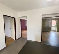 The interior of a 3-room apartment with wooden flooring and a room with a balcony.