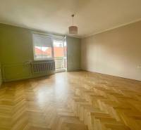 A room with parquet floors and an open balcony in a 3-room apartment.