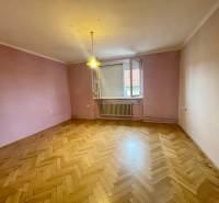 A room with a parquet floor and purple walls in a three-room apartment.