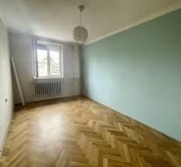 An empty room with parquet flooring and an open window in a 3-room apartment.