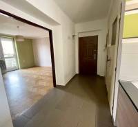 Entrance hallway with wooden flooring and an open passage to the living room in a 3-room apartment.