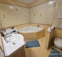 Bathroom with a bathtub, sink, washing machine, and toilet in a 3-room apartment.