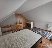 Attic room in a 3-room apartment with a bed, dresser, and carpet.