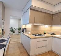 A kitchen in a 2-room apartment with a dining table and wooden elements.