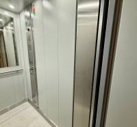 The interior of the elevator in a 4-room apartment, with a control panel and a mirror.
