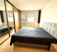 A bedroom in a 4-room apartment with a double bed and a built-in wardrobe with a mirror.