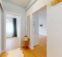 Hallway of a 2-room apartment with wooden floors, a mirror, and decorations.