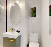 Bathroom in a 2-room apartment with white tiles and a shower corner.
