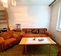 Living room in a 3-room apartment with a sofa and an armchair with a carpet and a table.