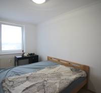 Bedroom in a 3-room apartment with a bed, window, and a small table.