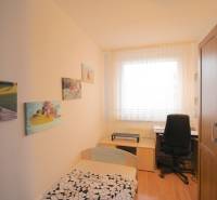 Children's room in a 3-room apartment with furniture, pictures on the wall, and a desk.
