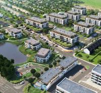 Aerial view of a residential complex, parking lot, and pond, suitable for a 3-room apartment.