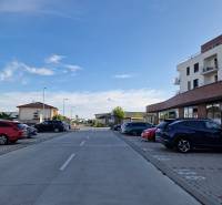The road on Vtáčia Street in Senec, lined with buildings and parked cars, Gastro premises.