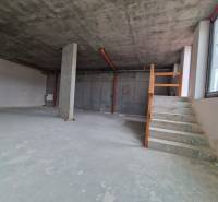 Empty interior of gastro spaces with stairs and a concrete pillar.