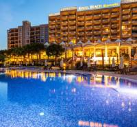 Night view of a Holiday Apartment in Sunny Beach with a lit pool and relaxation area.