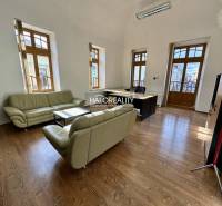 Offices with wooden floors, leather sofas, and large windows.
